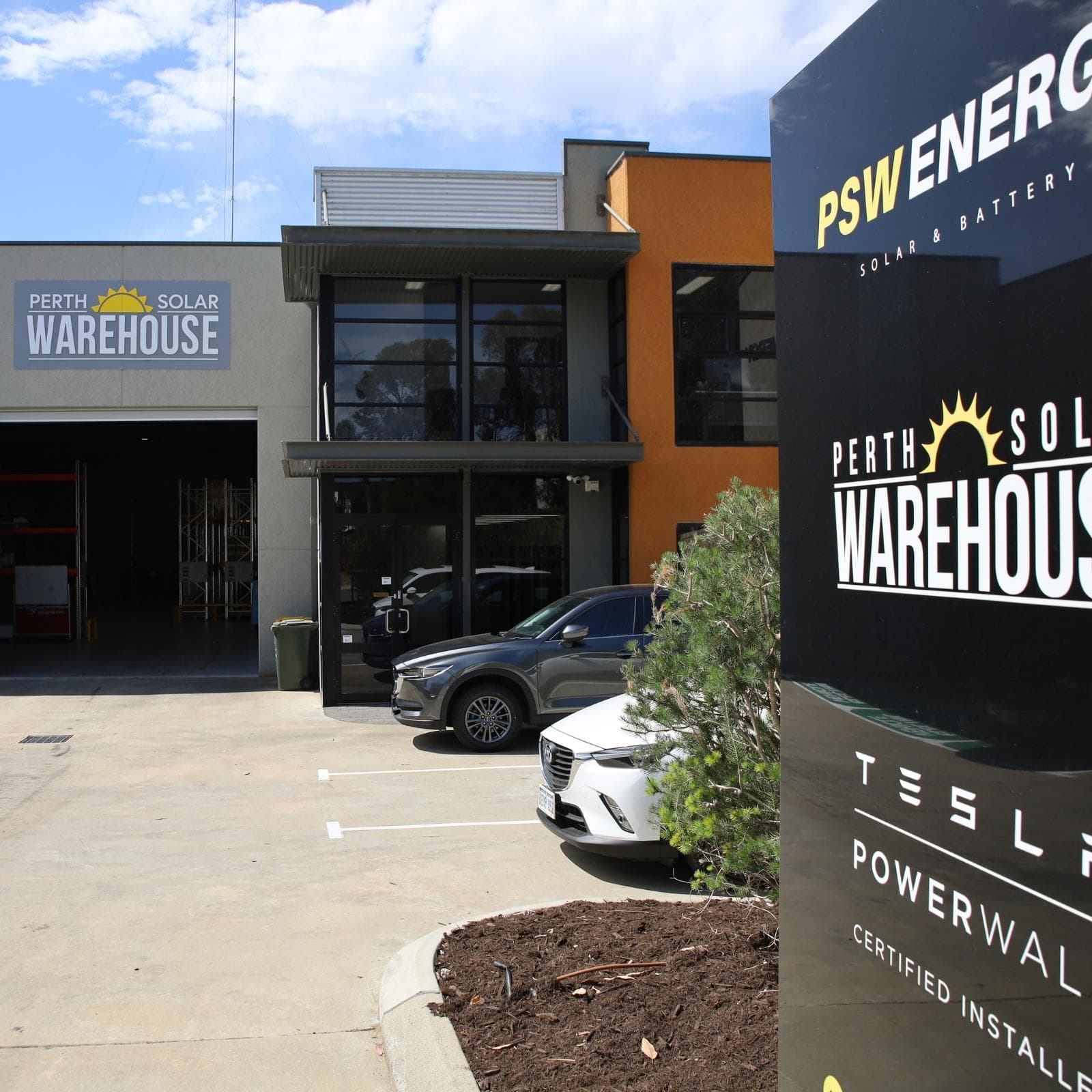 The Bibra Lake premises, with Perth Solar Warehouse signage on the building and a PSW Energy pylon sign at the entrance.